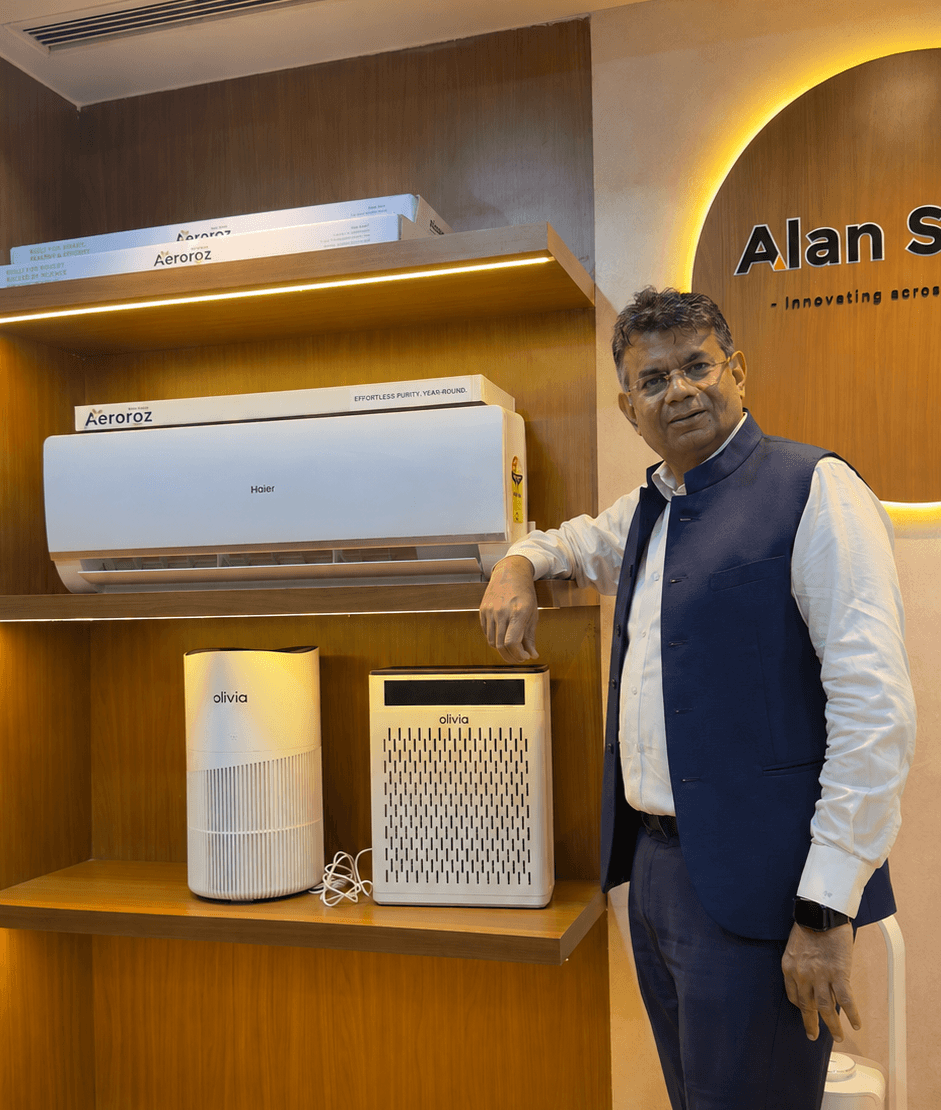 EnviroTech founder seated beside an air purifier